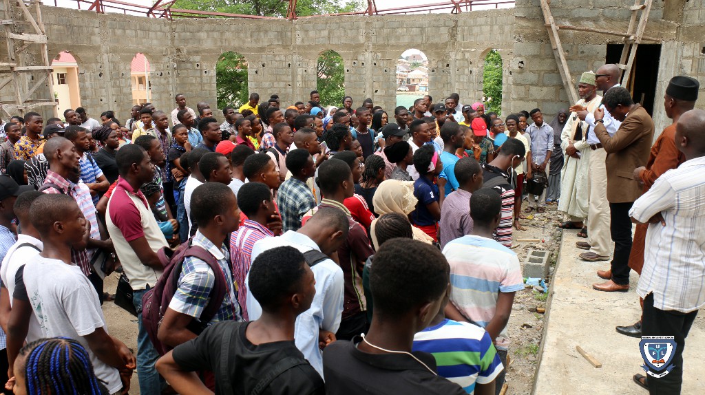Fresh students and the two religious leaders at the Chapel of Grace church building which is still under construction