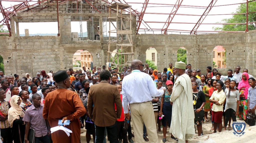 Fresh students and the two religious leaders at the Chapel of Grace church building which is still under construction
