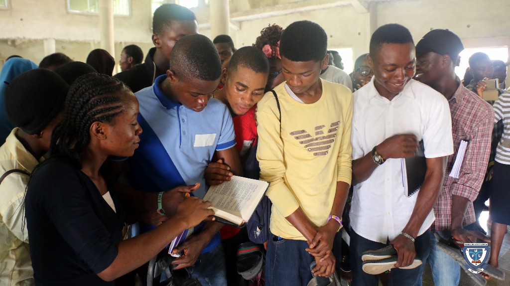 A group of fresh students flipping through the pages of the Holy Quran during a tour to the University Central Mosque to demonstrate brotherliness among the two religious bodies on campus as part of the orientation exercise