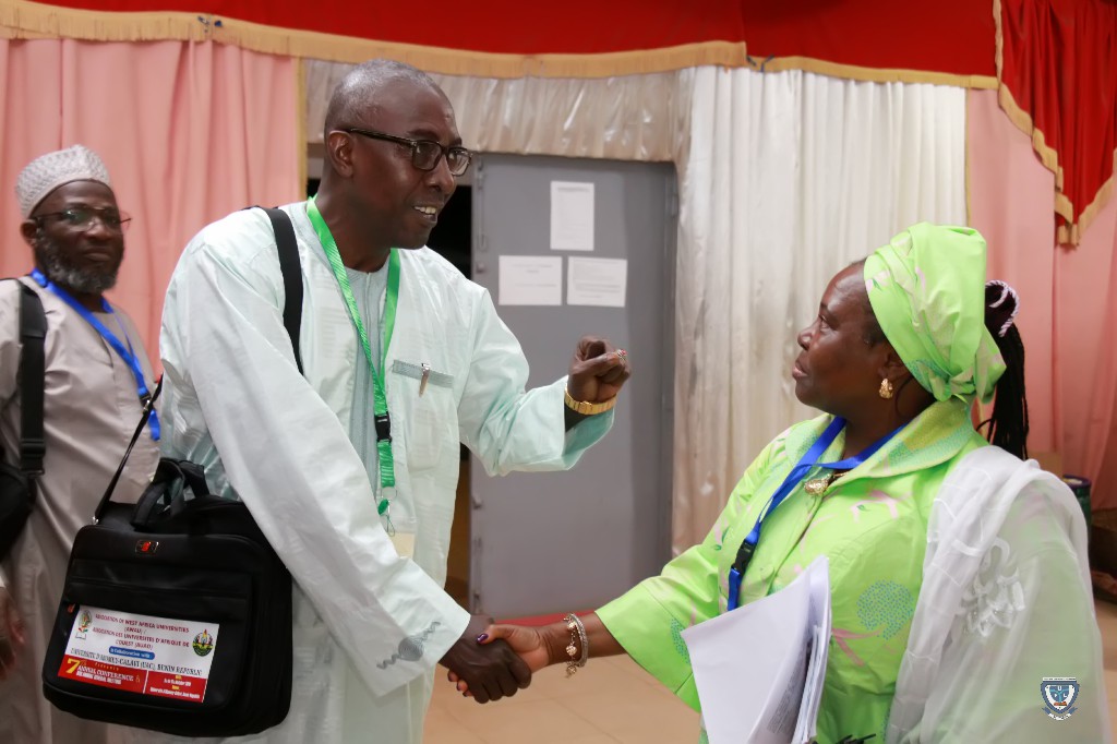The Vice-Chancellor, Prof. Angela F. Miri in a warm handshake with one of the participants at the 7th Conference and 9th AGM of the Association of West Africa Universities held in Benin Republic